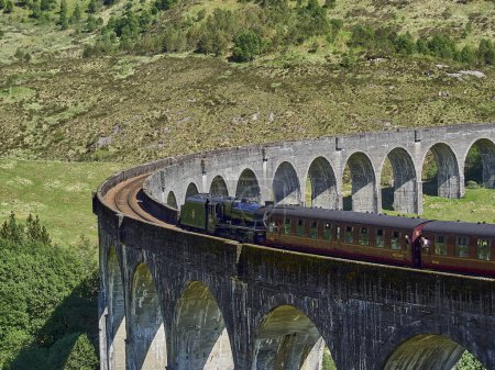 Glenfinnan, Scotland - 05 29 2018: iconic jacobite steam train crossing the Glenfinnan viaduct in the scottish highlands.