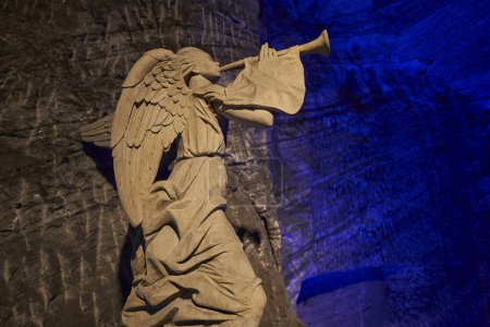 Foto de Zipaquira, Colombia - 04 12 2019: escultura de ángel y cruz gigante en la catedral católica de Zipaquira está construido en los túneles de una mina de sal subterránea y artísticamente iluminado con luz de colores. - Imagen libre de derechos
