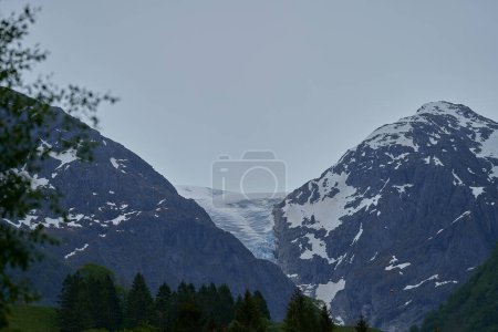 Glacier Blue Bondhusbreen suspendu dans les montagnes au-dessus du lac Bondhusvatnet et à Sundal, Vestland, Norvège