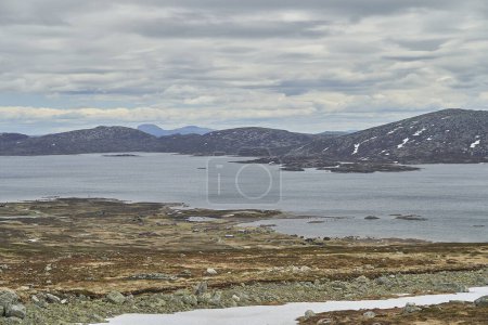 Téléchargez les photos : Lac dans le paysage montagneux de Jotunheimen en Norvège, avec des sommets enneigés en arrière-plan, une destination de voyage populaire pour la randonnée. - en image libre de droit