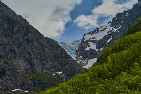 Blue Bondhusbreen Glacier hanging in the mountains over the Bondhusvatnet Lake and in Sundal, Vestland, Norway