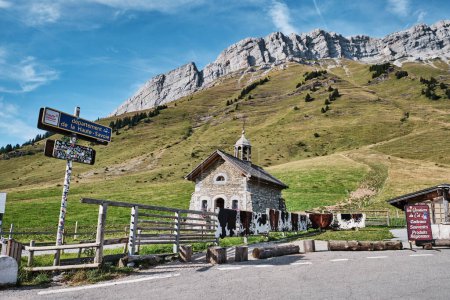 kleine Steinkapelle in den französischen Alpen im Sommer mit grünen Wiesen und Bergen