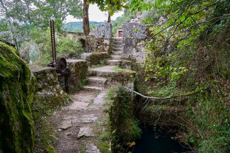 alte Kopfsteinpflasterstraße zum antiken römischen Ponte Mizarela, oder Teufelsbrücke mit einem schönen Bogen und malerischem Wasserfall, im Peneda Geres Nationalpark in Portugal, Europa