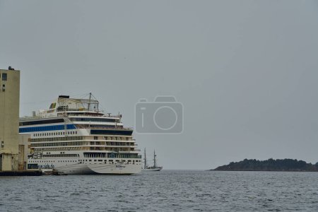Foto de Kristiansand, Noruega 06 17 2022: puerto en Kristiansand con un crucero y tres mástil marinero en el fondo. - Imagen libre de derechos