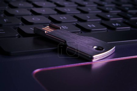 Téléchargez les photos : Clé USB sous la forme d'une touche sur un clavier d'ordinateur portable gros plan. Illuminé avec violet, lumière violette, mise au point douce. - en image libre de droit
