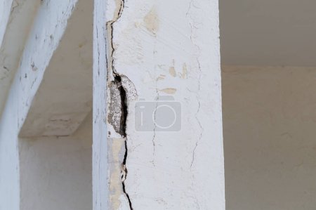 Cracked, damaged column close-up. Damage to the building's supporting structures.