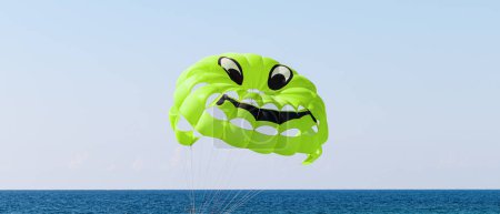 A bright green parachute with a smiley face design. Parasailing in the sea.