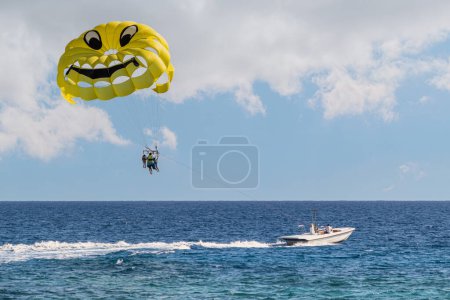 Photo for Parasailing in the sea. A popular tourist pastime with a parasailing parachute attached to a motorboat. - Royalty Free Image