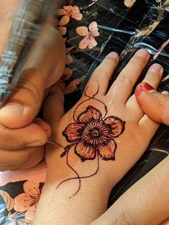 Téléchargez les photos : Une main ornée de motifs au henné complexes, tourbillonnant de brun rougeâtre, créant une œuvre d'art captivante et temporaire. Points focaux sélectifs - en image libre de droit