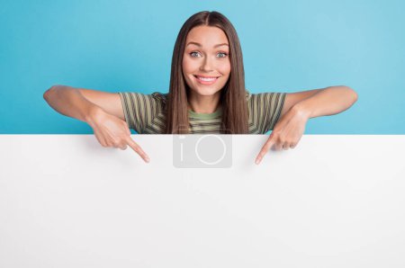 Photo of positive cheerful nice pretty woman with long hairstyle wear striped t-shirt directing poster isolated on blue color background.