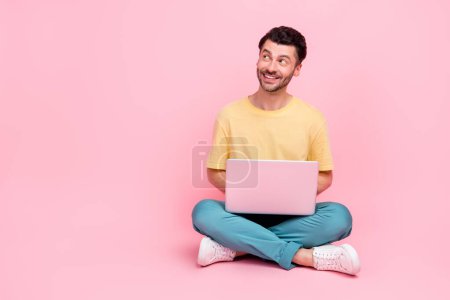 Photo of positive man wear stylish clothes look empty space black friday low price gadget device isolated on pink color background.