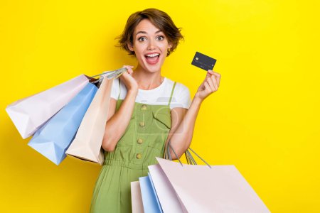 Photo concept of young charming excited crazy woman hold new plastic card payment for shopping gifts crazy isolated on yellow color background.