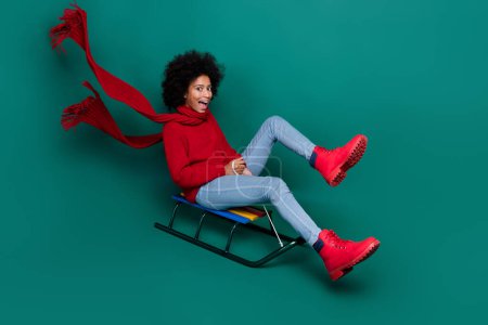 Full body profile photo of excited overjoyed person ride sledge isolated on green color background.