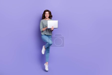 Full length photo of adorable nice lady wear trendy clothes rejoice new quality purchase empty space isolated on purple color background.
