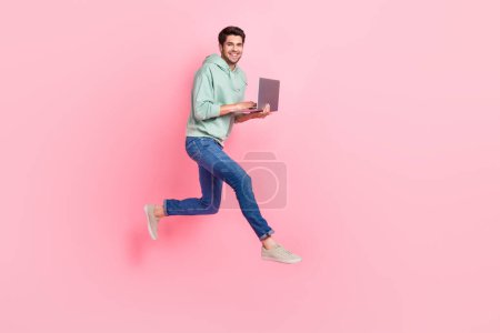 Full length photo of cheerful positive office worker wear stylish outfit go empty space device sale isolated on pink color background.