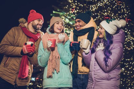 Photo of group positive cheerful people enjoy hot chocolate speak communicate noel miracle outdoors.