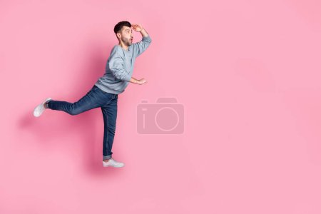 Full body photo of nice young guy carry cart look empty space hand forehead dressed trendy blue clothes isolated on pink color background.