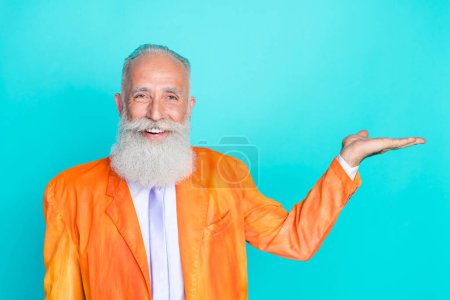 Foto von positiven lustigen Rentner Kerl tragen neonorangefarbene Jacke Arm leer Raum isoliert Krickente Farbe Hintergrund.