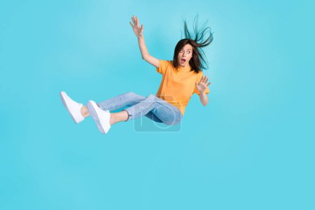 Full length photo of anxious embarrassed girl person look empty space fly down isolated on blue color background.
