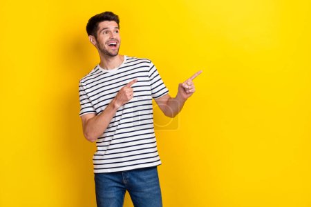Photo of young overjoyed excited student man wear stylish casual outfit look interested finger direct mockup isolated on yellow color background.