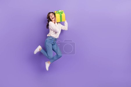 Full length photo of overjoyed crazy lady hold purchase rejoice holiday event good mood empty space isolated on purple color background.