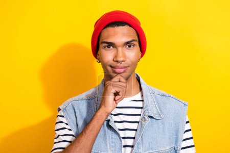Portrait of creative clever person hand touch chin brainstorming red headwear isolated on yellow color background.