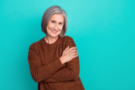 Photo of adorable glad senior lady pensioner wear trendy clothes promoting stylish collection empty space isolated on cyan color background.