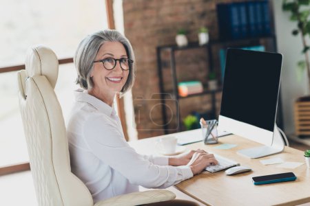 Photo of smiling happy lady cep wear spectacles white shirt working modern device indoors workplace workshop.