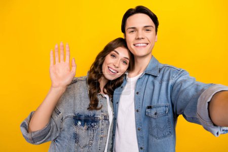 Photo of attractive girl handsome man take selfie record video arm palm waving hi isolated on yellow color background. Poster 645232878
