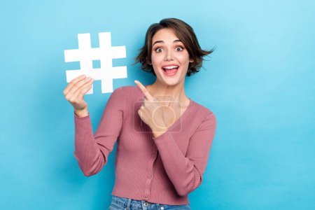 Photo of sweet impressed woman dressed pink shirt pointing finger hash tag isolated blue color background.