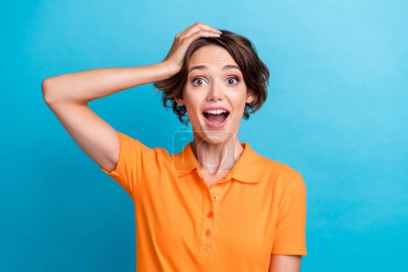 Photo of girly shocked girl dressed orange polo arm head open mouth isolated blue color background.