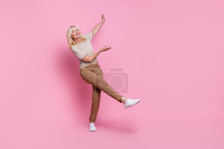 Foto in voller Länge von fröhlich froh Frau gekleidet schönes Outfit präsentiert leeren Raum isoliert auf rosa Hintergrund.