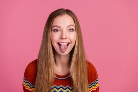 Foto de alegre chica alegre sonrisa dentada mostrando la lengua hacia fuera el espacio vacío aislado sobre fondo de color rosa.