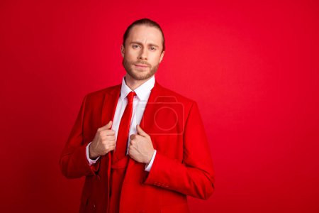 Foto retrato de elegante chaqueta de toque masculino joven tratar de posar vestido elegante prenda clásica aislada sobre fondo de color rojo.