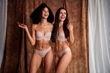 Photo of excited funny women wear beige lingerie no retouch skin hugging smiling isolated natural daylight fabric linen background.