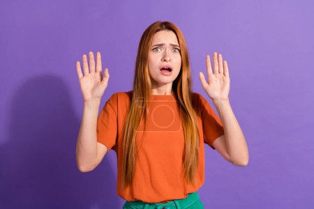Close up photo of amazed young red hair girl raised arms up when horrified looking at scary monster isolated on purple color background.