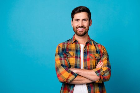 Photo portrait of handsome young male folded hands cheerful smile dressed stylish checkered outfit isolated on blue color background.