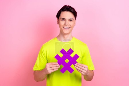 Photo portrait of handsome teen male hashtag number symbol dressed stylish yellow garment isolated on pink color background.