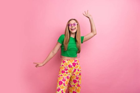 Foto retrato de encantadora dama adolescente divertirse bailando enérgico desgaste ropa verde de moda aislado en el fondo de color rosa.