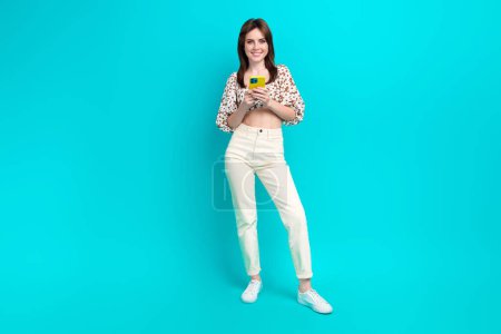 Full length photo of sweet positive lady dressed top chatting instagram twitter telegram facebook empty space isolated turquoise color background.