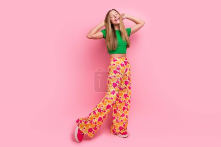 Full length photo of dreamy shiny sweet cheerful girl dressed trendy clothes hand touch head good mood isolated on pink color background.