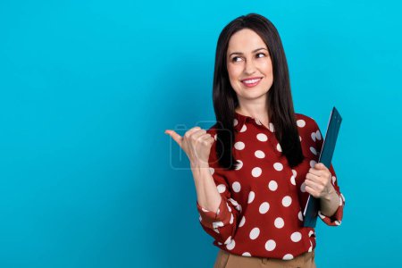 Photo of intelligent woman dressed dotted shirt hold clipboard look directing at promo empty space isolated on blue color background.