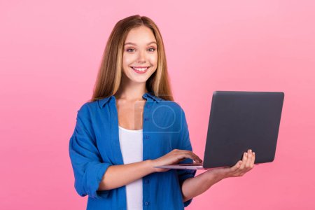 Photo of sweet charming lady dressed blue shirt preparing homework modern gadget empty space isolated pink color background.