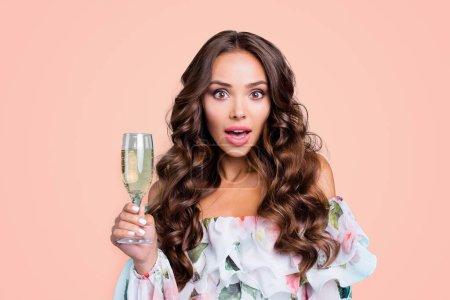 Close up portrait of brunette lady with glass of alcohol in hands look at camera with wide open mouth and big eyes isolated on vivid teal background.