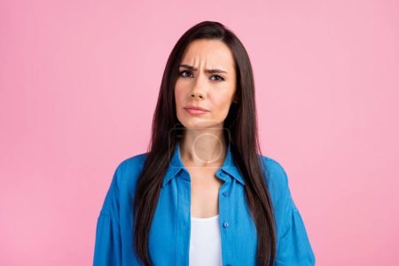 Photo of puzzled minded intelligent nice girl with straight hairdo dressed blue shirt look at camera isolated on pink color background.
