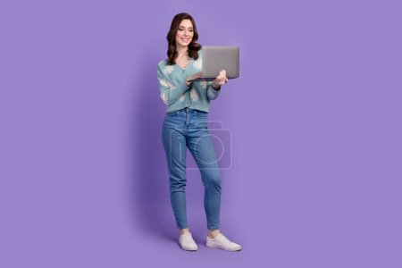 Full length photo of pretty positive lady dressed flower print cardigan communicating device empty space isolated violet color background.