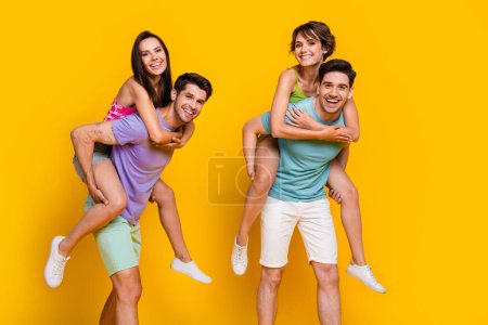 Foto de cuatro personas jóvenes tienen vacaciones juntos piggybacking aislado color brillante fondo.