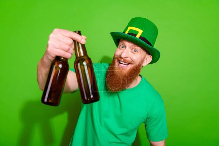 Photo of funky friendly person arm hold give you glass beer bottles isolated on green color background.