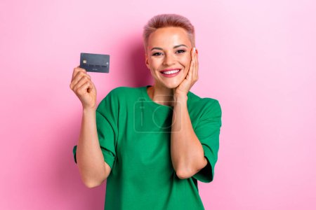 Photo of cute lovely adorable woman wear green trendy clothes demonstrate debit credit card nfc function isolated on pink color background.