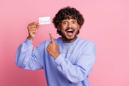 Photo of excited cheerful guy wear blue stylish clothes recommend buy with card cashless payment isolated on pink color background.